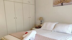 Une chambre à coucher avec un lit, une table de chevet, une lampe et une armoire.