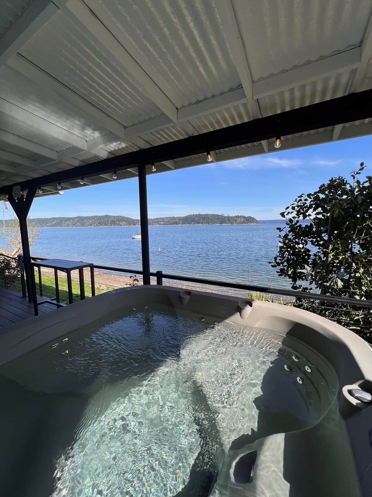 Un jacuzzi con vistas a un lago y terreno lejano.