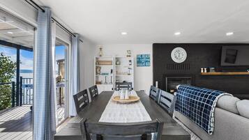 Un comedor con una mesa y sillas, una estantería, un reloj y una chimenea.