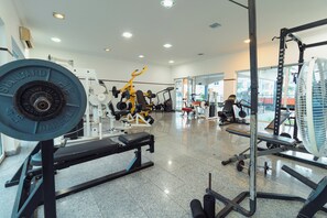 Work out in style with a fully equipped gym featuring a barbell, bench, and various exercise machines.