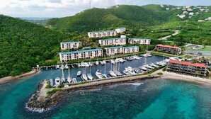 A marina with multiple boats docked, surrounded by lush greenery and a mountainous backdrop. - Renovated Charming Studio Retreat with Stunning Caribbean Views (St Thomas)