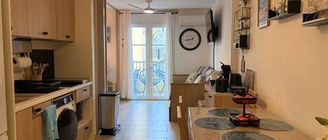 Una cocina con lavadora, una mesa de comedor con individuales y un ventilador de techo.