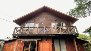 Una casa in legno con un balcone e un cartello di benvenuto.