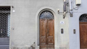 A building with a wooden double door, a metal gate, and a number 21 sign. - Classic Florence A By MMega (Firenze)