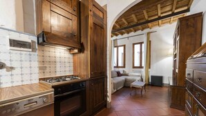 A kitchen with wooden cabinets, a gas stove, and a tiled backsplash. - Classic Florence A By MMega (Firenze)