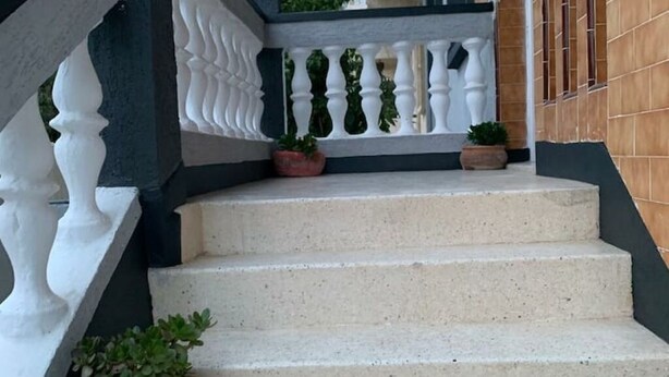 A set of beige stone steps leading to a white balustrade with a small potted plant on the landing. - Villa Moon (Essaouira)