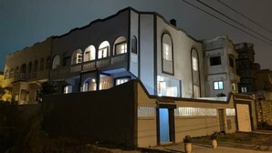 A modern two-story building with a balcony on the second floor, a garage, and a small garden area with potted plants. - Villa Moon (Essaouira)