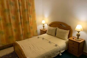 Cozy bedroom with a single bed, bedside tables, and a window with a view.
