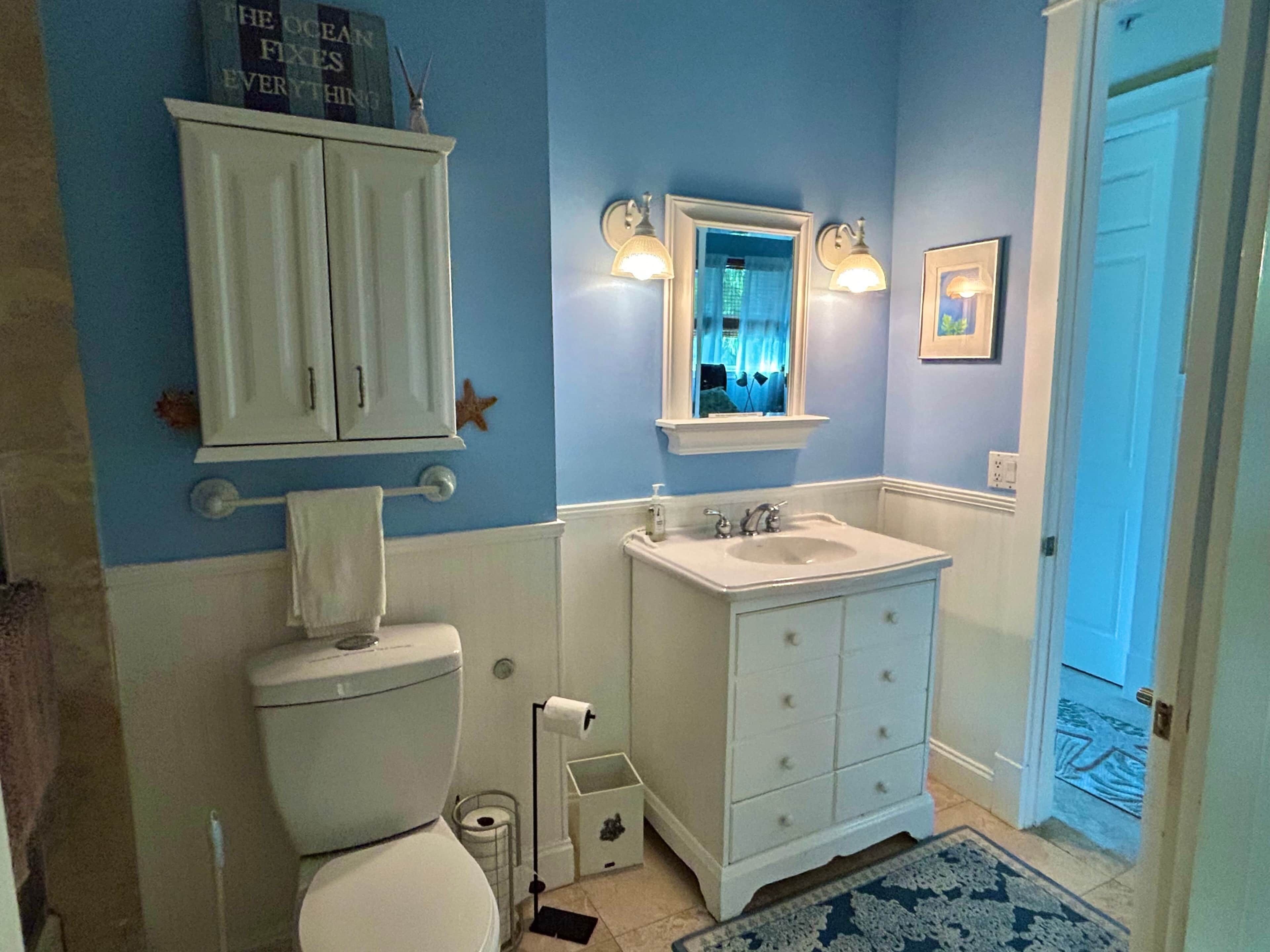 Ein Badezimmer mit Toilette, Waschbecken und Schrank.