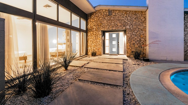 A modern house with a stone facade, large glass windows, and a swimming pool. - 4bd, Charming Mid-Century Home! 1.4mi to Convention Center, Mins to Strip! POOL! (Las Vegas)
