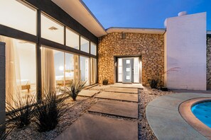 A modern house with a stone facade, large glass windows, and a swimming pool. - 4bd, Charming Mid-Century Home! 1.4mi to Convention Center, Mins to Strip! POOL! (Las Vegas)