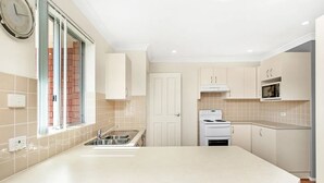 A modern kitchen with a central island, a built-in oven, and a microwave.