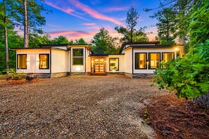 A modern house with a gravel driveway and a well-maintained garden. - 1-Story Stay | Hot Tub, PingPong, Arcade & Playset (Broken Bow)
