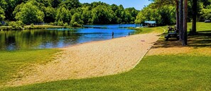 A lakeside park with a sandy beach, grassy areas, and a small structure in the background. - Ping Pong, Foosball, Playset in 1 Story Fun Cabin (Broken Bow)