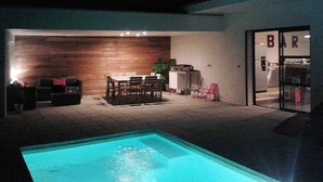 An outdoor patio with a pool, a dining area with a table and chairs, and a bar area with a sign. - Near Uzès, holiday air-conditioned villa located Vers-Pont-du-Gard, private pool. (VERS-PONT-DU-GARD)