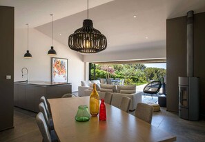 Relax in this open-plan living space with a dining area, comfortable seating, and a kitchen.