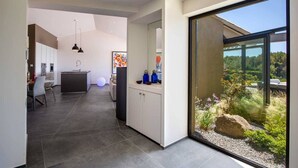 A modern interior with a kitchen, dining area, and a large sliding glass door leading to a garden. - Exceptional air-conditioned house, swimming pool in Ollioules, Var, near Sanary-sur-Mer. (OLLIOULES)