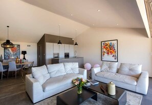 Relax in this stylish living space with a comfortable L-shaped sofa, coffee table, and dining area.