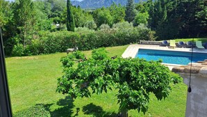 A backyard with a swimming pool, a tree, and a mountain view. - Superb air-conditioned farmhouse with private pool, in Saint-Rémy-de-Provence. (SAINT-REMY-DE-PROVENCE)