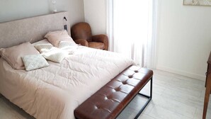 Un dormitorio con cama, una silla y un banco.
