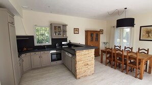Una cocina moderna con una isla central, armarios de madera y una zona de comedor con mesa y sillas.