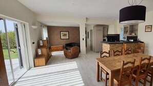 Una cocina amplia con comedor, chimenea de piedra y un mueble grande de madera.