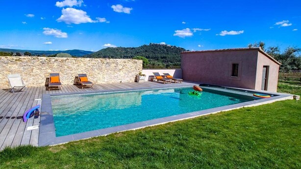 A swimming pool with lounge chairs and a small building, surrounded by a stone wall and grass. - Holiday rental in Le Castellet, sea and beach 10 km. (LE CASTELLET)