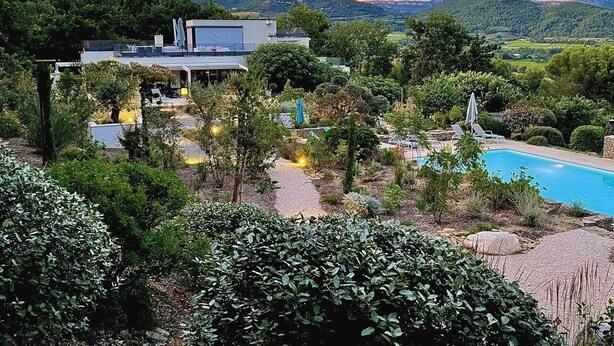 A modern house with a pool, surrounded by lush greenery and hills in the background. - Air-conditioned villa near Vaison-la-Romaine, with heated pool. (FAUCON)