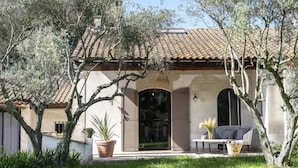 A Mediterranean-style villa with a tiled roof, arched windows, and a covered patio area with outdoor seating. - Villa for 8P, heated pool, table tennis, boules, in Maillane, Alpilles, pets admitted (1). (MAILLANE)