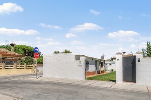 Zona residencial privada con una señal de parada, un letrero azul direccional y un edificio con un cartel que dice 'EL OLIVO'.