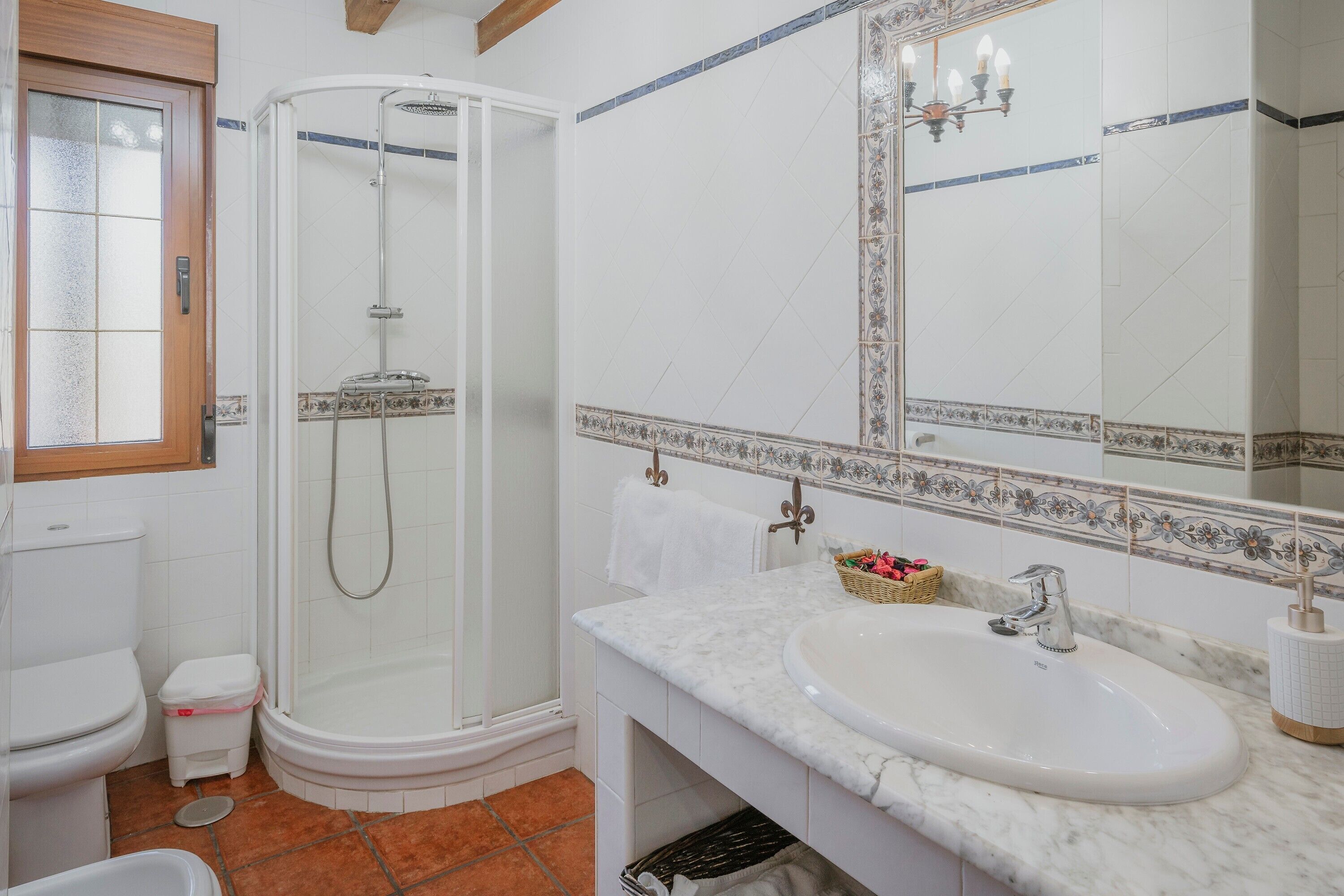 Ein Badezimmer mit Dusche, Toilette, Waschbecken und einem großen Spiegel.