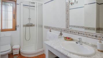 Ein Badezimmer mit Dusche, Toilette, Waschbecken und einem großen Spiegel.
