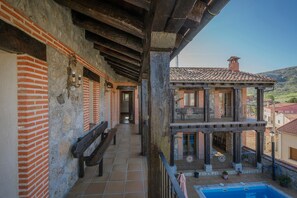 A building with a balcony, a pool, and a view of the surrounding area. - Country House 'Las Eras De Riofrio' with Mountain View, Private Pool and Wi-Fi (Riofrio)