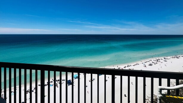 A beach view from a balcony with a railing, clear blue sky, and turquoise sea. - Paradise Found On the Beach PH16 (Panama City Beach)