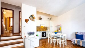 Un apartamento moderno con cocina, comedor y una escalera que lleva a otra habitación.
