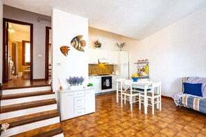 Eine moderne Wohnung mit Küche, Essbereich und einer Treppe zu einem weiteren Raum.