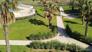 A resort with a pool, palm trees, and a view of the ocean. - Splendid sea view for this T2 in residence with swimming pool - 4GOEL248 (SAINT CYPRIEN PLAGE)