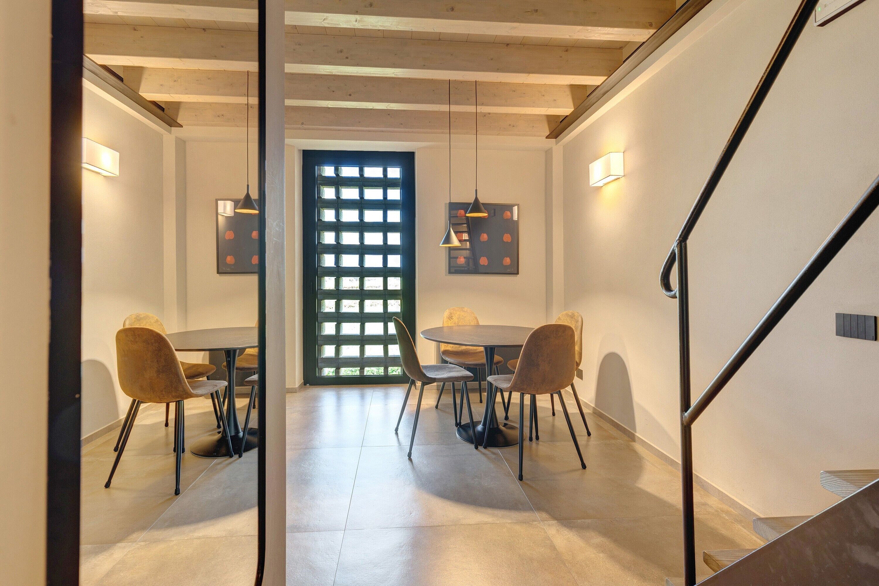 Un espace repas comprenant une table ronde, des chaises et des luminaires suspendus.