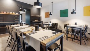 Un comedor moderno con varias mesas, sillas e iluminación colgante.