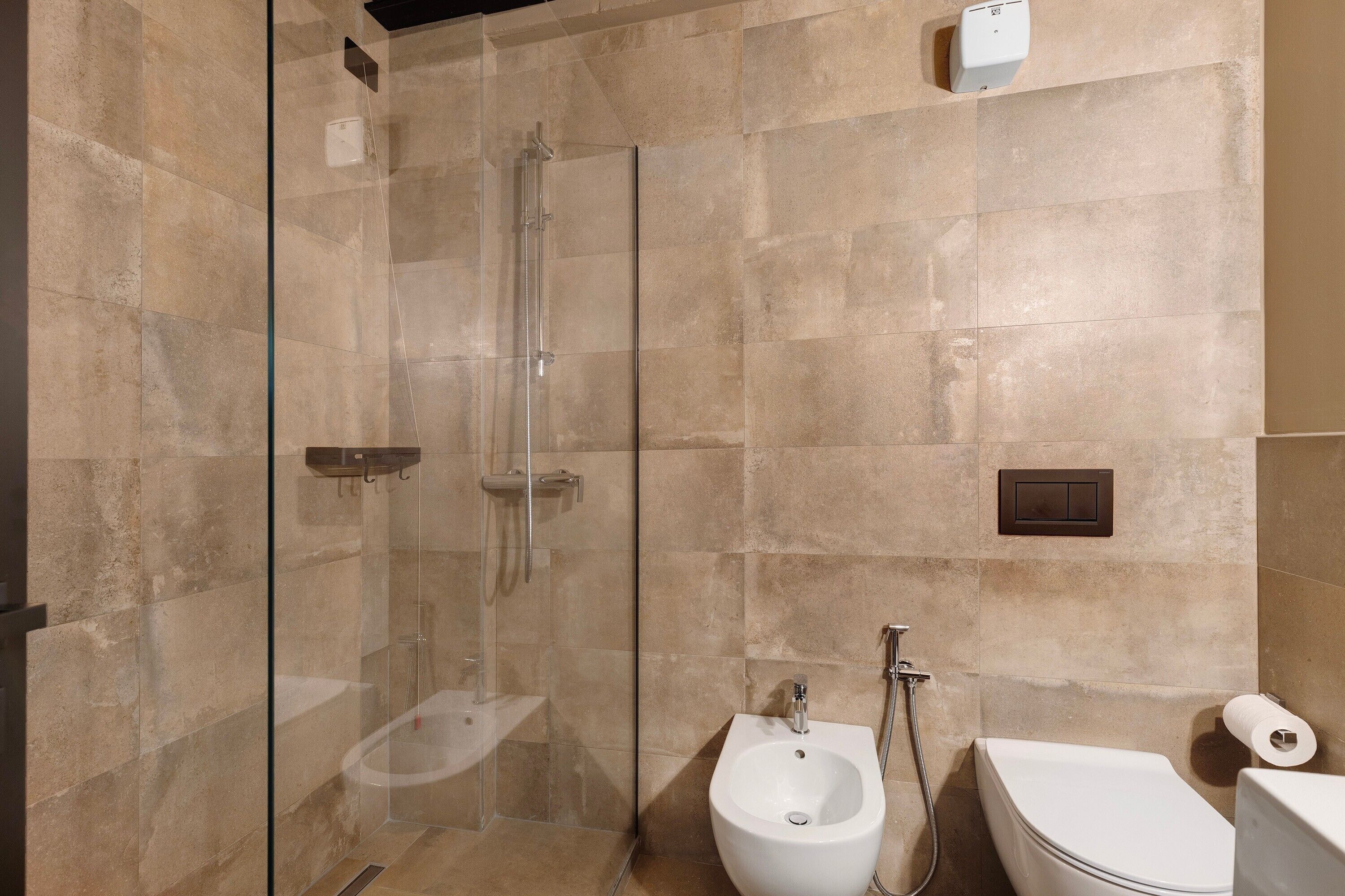 Ein modernes Badezimmer mit einer Duschkabine, einem Bidet und einer Toilette.