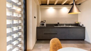 A modern kitchen with dark cabinetry, a built-in microwave, and a hanging pendant light. - Apartment 'Agr Casa Pezzo 2' with Shared Pool, Wi-Fi and Air Conditioning (Castelnuovo del Garda)