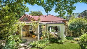 Ein Haus mit Ziegelaußenwand, rotem Dach und einer Veranda.