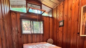 A wooden room with a bed, a window, and a fan. - Welcome to the Wolf Den on Wolf Lake! (North Lawartha)