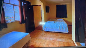 Una stanza con un letto, una finestra e una porta.