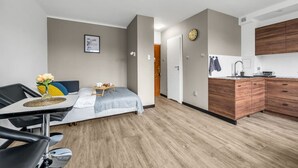 Un apartamento moderno con cama, comedor, cocina y baño.