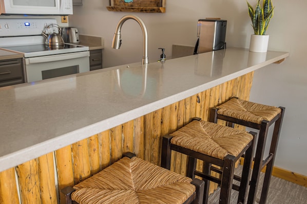 A kitchen with a large island, stainless steel appliances, and wooden accents.