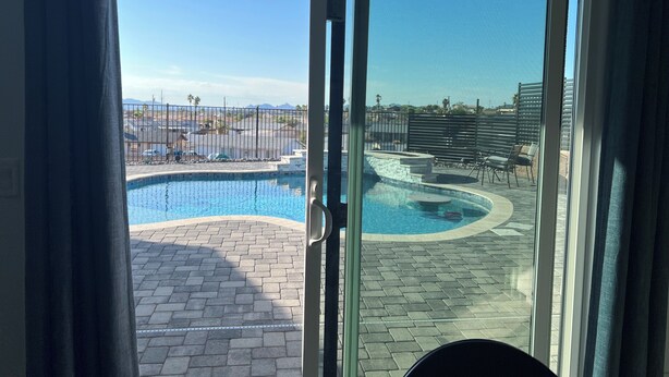 A view of a swimming pool with a clear sky and distant mountains.