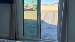 A bedroom with a large sliding glass door leading to an outdoor area.