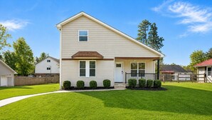 A two-story house with a front porch, a garage, and a well-maintained lawn. - Tranquil Retreat Near Lake Norman – Cozy, Spacious & Perfect for Relaxation! (Denver)