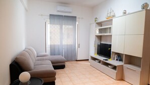 Sala de estar con sofá, televisor y unidad de almacenamiento.